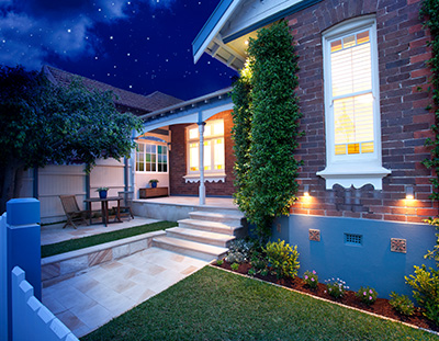 Image of house at night with tailored landscaping