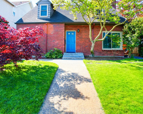 Image of brick house with blue door and nice landscape
